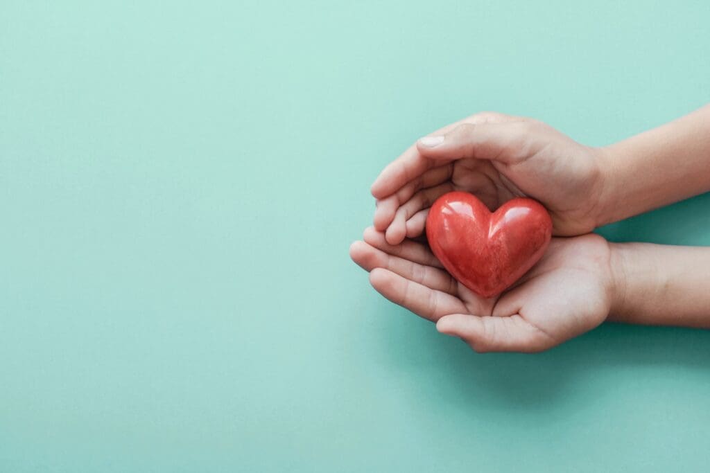 Person holding a red heart for Valentine's Day.