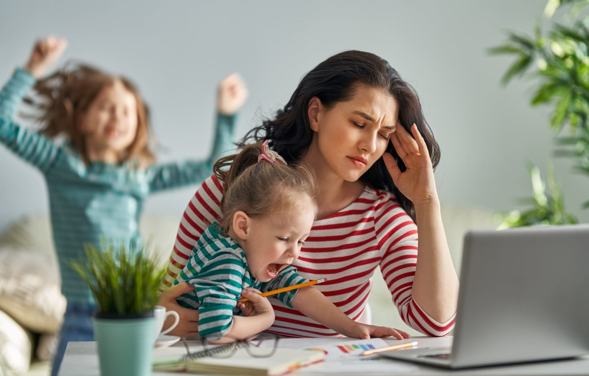 attachment-6604dfae8e36614a3595f954 Stressed mother working with playful children.