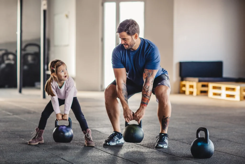 Dad and daughter lifting weights in gym as part of FIFO lifestyle.