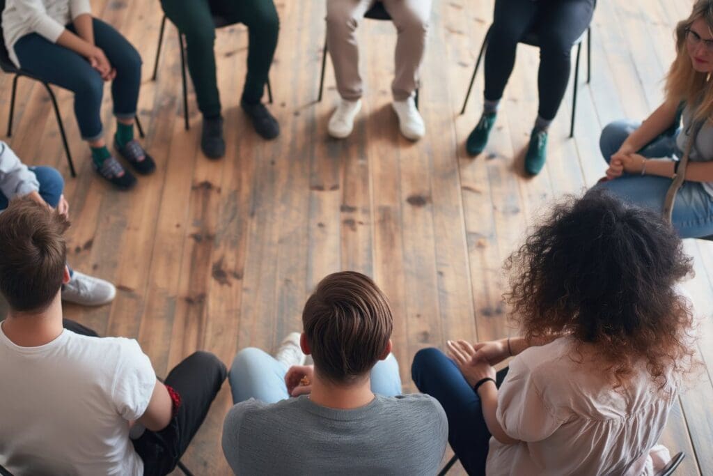 A group of people sitting together is a supportive community.