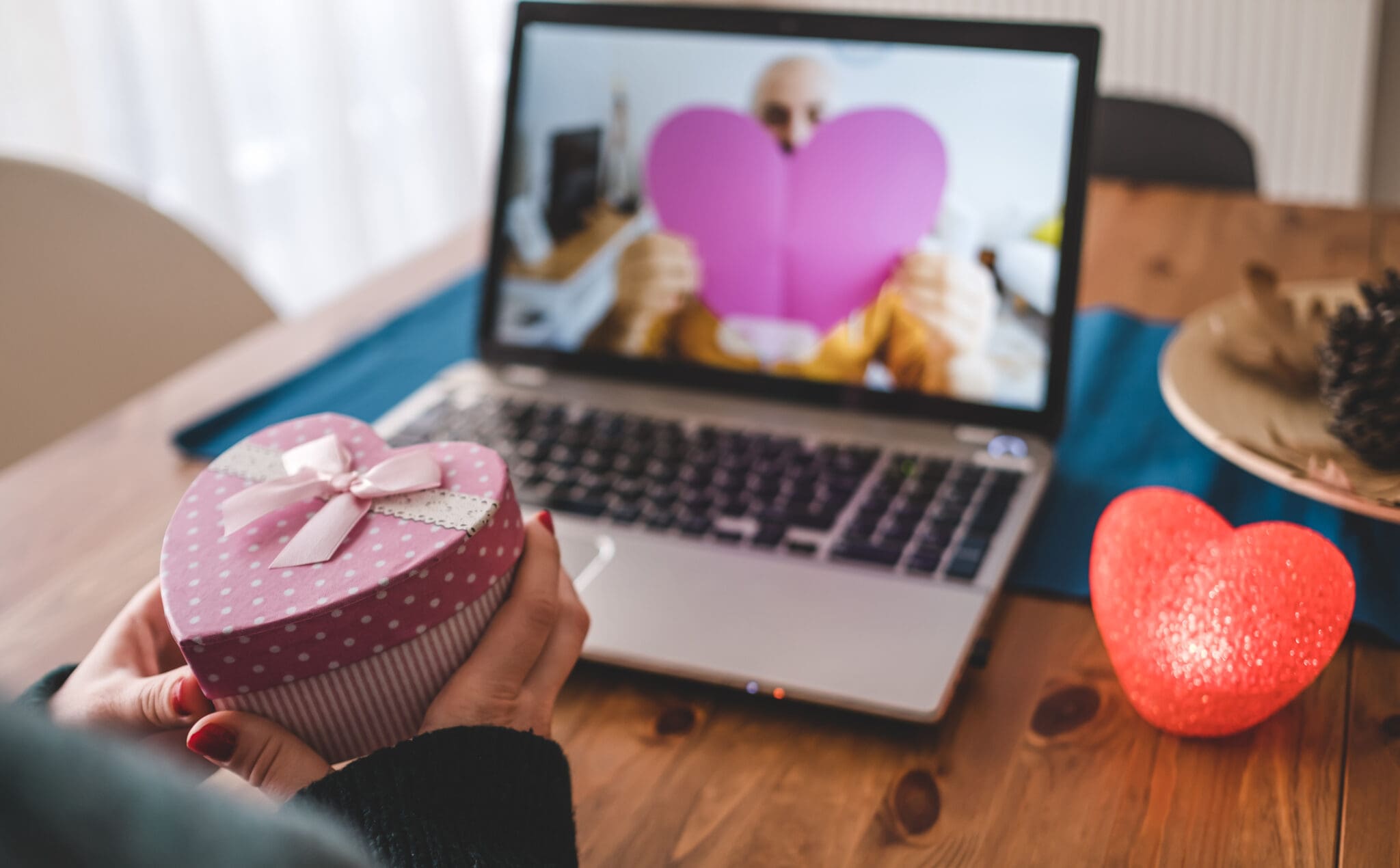 Couples giving gifts with their girlfriend via video conference. Girlfriend and boyfriend exchange Valentine's Day gifts virtually.