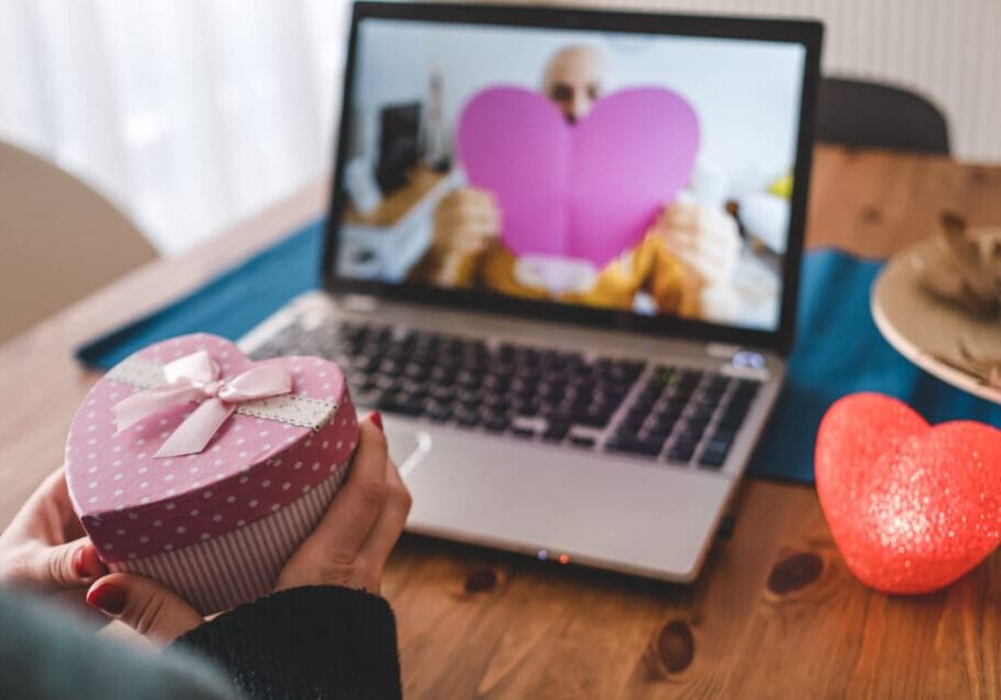Couples giving gifts with their girlfriend via video conference. Girlfriend and boyfriend exchange Valentine's Day gifts virtually.