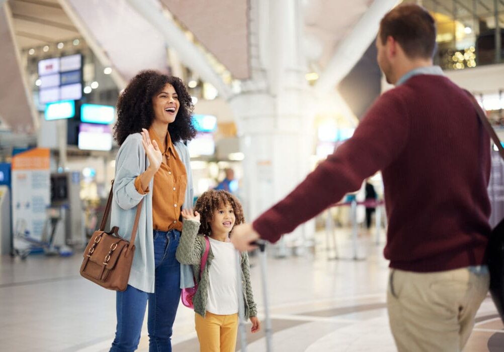 Happy family greeting father at airport for welcome home, reunion and travel immigration at international flight. Interracial mother, dad and girl or kid wave, hello and excited to see papa in lobby Goodbyes and reunions with a family.